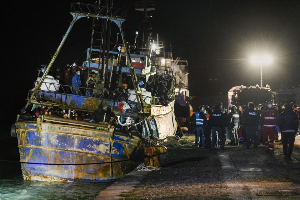 Police check a fishing boat with some 500 migrants in the southern Italian port of Crotone, early Saturday, March 11, 2023. The Italian coast guard was responding to three smugglers boats carrying more than 1,300 migrants “in danger” off Italy’s southern coast, officials said Friday. Three small coast guard boats were rescuing a boat with 500 migrants about 700 miles off the Calabria region, which forms the toe of the Italian boot. (AP Photo/Valeria Ferraro)