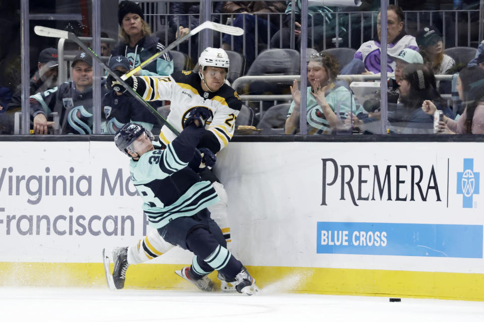 Seattle Kraken right wing Jesper Froden (38) collides with Boston Bruins defenseman Hampus Lindholm (27) during the third period of an NHL hockey game Thursday, Feb. 23, 2023, in Seattle. The Bruins won 6-5. (AP Photo/John Froschauer)