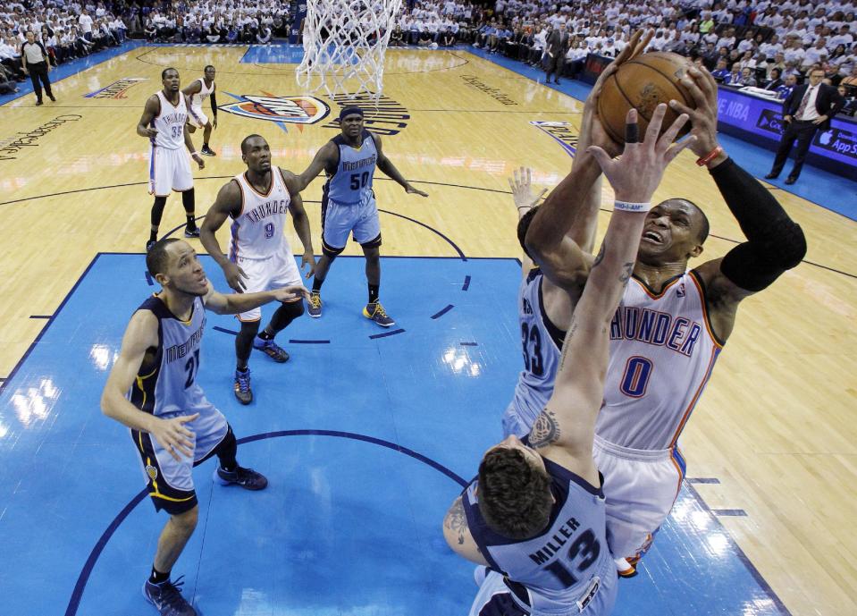 Oklahoma City Thunder guard Russell Westbrook (0) is double teamed by Memphis Grizzlies center Marc Gasol (33) and forward Mike Miller (13) as he shoots in the second quarter of Game 5 of an opening-round NBA basketball playoff series in Oklahoma City, Tuesday, April 29, 2014. (AP Photo)