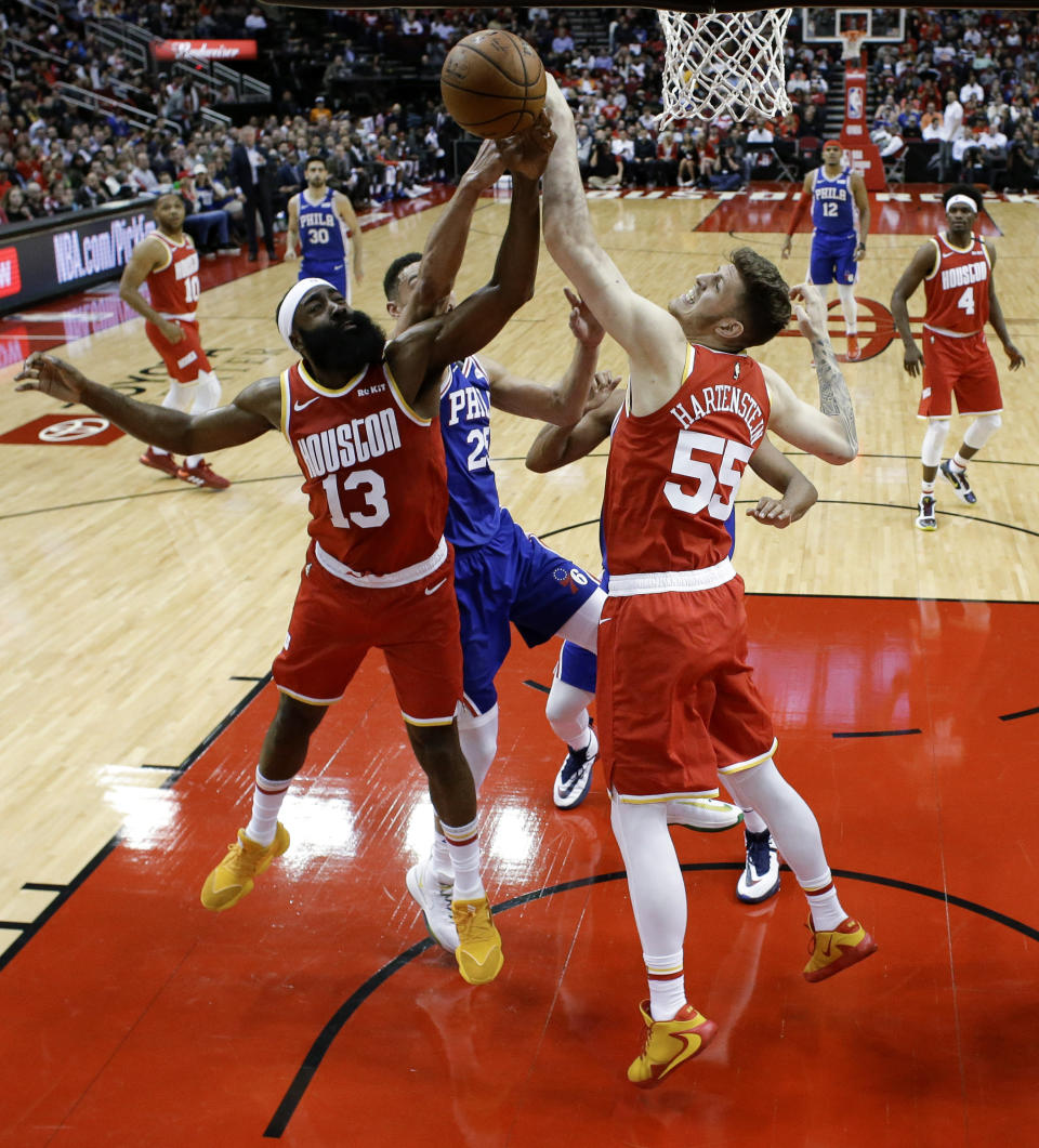 Houston Rockets center Isaiah Hartenstein (55) and guard James Harden (13) and Philadelphia 76ers guard Ben Simmons, center, vie for a rebound during the first half of an NBA basketball game Friday, Jan. 3, 2020, in Houston. (AP Photo/Eric Christian Smith)