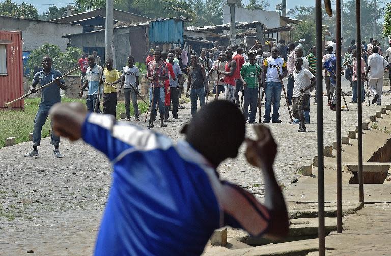 A protester opposed to Burundian President Pierre Nkurunziza running for a third term, throws a rock at members of the Imbonerakure, the youth wing of the ruling party, in the Kinama neighborhood of Bujumbura on May 25, 2015