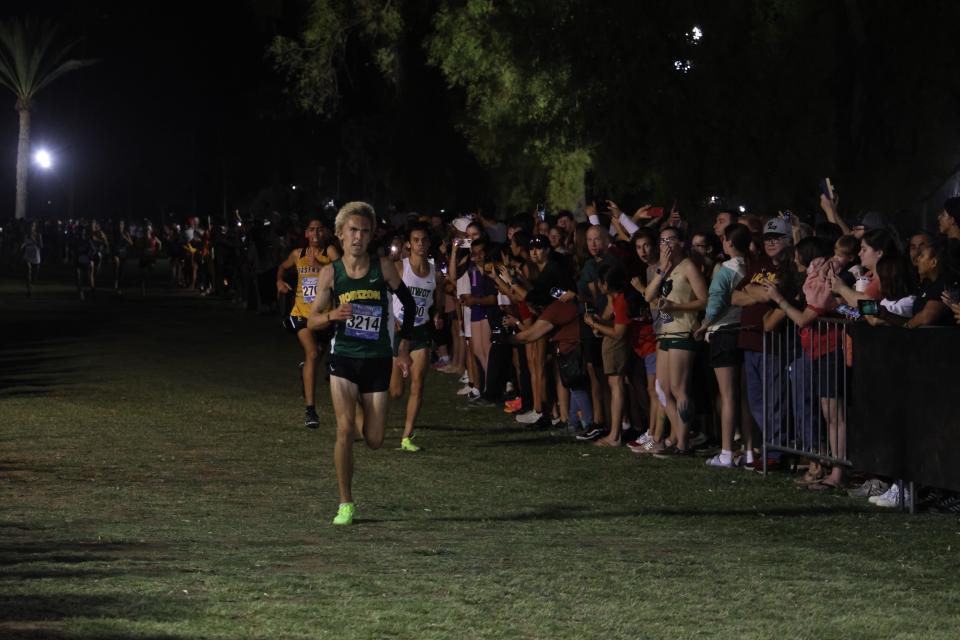 Scottsdale Horizon senior Donovan Bitticks runs down the final straightaway on his way to a first-place finish in the Boys Sweepstakes race at the Desert Twilight Cross Country Festival at Toka Sticks Golf Course in Mesa on Sept. 29, 2023. Bitticks ran a personal best time of 15:10.3 on the 5,000-meter course.