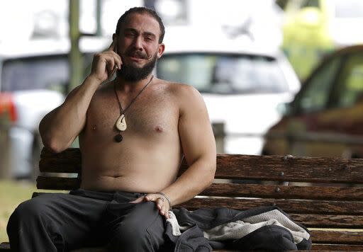 A tearful man reacts as speaks on a phone close to one of the Christchurch mosques (AP)