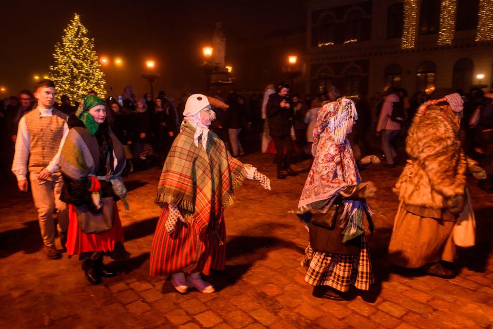 People wear folk costumes and pagan masks during the winter solstice celebration at the Town Hall Square on Dec. 21, 2022 in Riga, Latvia.  / Credit: GINTS IVUSKANS