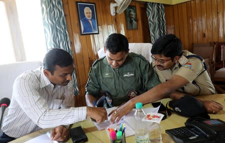 Vijay Kumar Jogdande discusses a plan of recovering the bodies of five climbers believed killed in an avalanche, with Indian Air Force pilot and a senior police officer in Pithoragarh