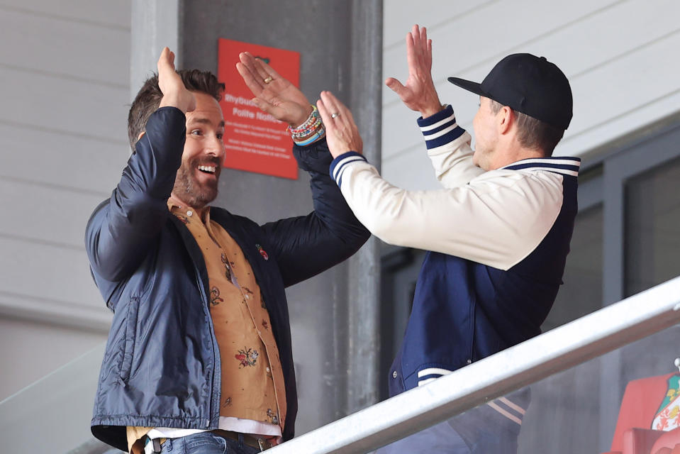 WREXHAM, WALES - APRIL 10: Wrexham co-owners Ryan Reynolds (L) and Rob McElhenney high-five each other before the Vanarama National League match between Wrexham and Notts County at the Racecourse Ground on April 10, 2023 in Wrexham, Wales. (Photo by Simon Stacpoole/Offside/Offside via Getty Images)