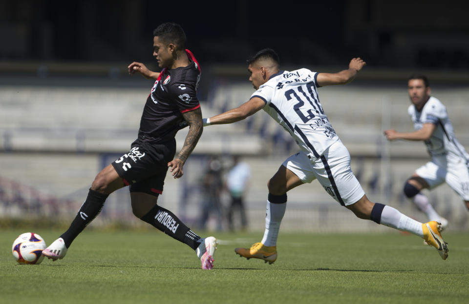 Daniel Guerrero (izquierda) de Atlas pugna el balón con Emannuel Montejano de Pumas durante el partido por el torneo Clausura de México, el domingo 31 de enero de 2021. (AP Foto/Christian Palma)