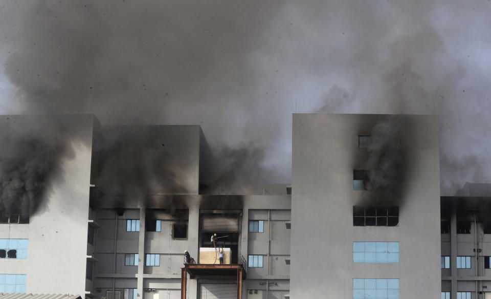 Firemen try to douse a fire at Serum Institute of India, the world's largest vaccine maker that is manufacturing the AstraZeneca/Oxford University vaccine for the coronavirus, in Pune, India, Thursday, Jan. 21, 2021. (AP Photo/Rafiq Maqbool)