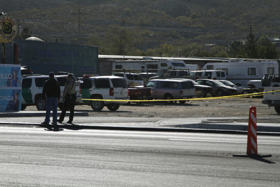 A local sheriff's deputy points with a water bottle to part of a crime scene of a fatal shooting on Monday, Nov. 4, 2019, in Sunland Park, New Mexico, a suburb of El Paso, Texas. Customs and Border Protection officials said an armed man was fatally shot by a Border Patrol agent after the gunman opened fire. The scene is about a mile from the U.S.-Mexico border. (AP Photo/Cedar Attanasio)