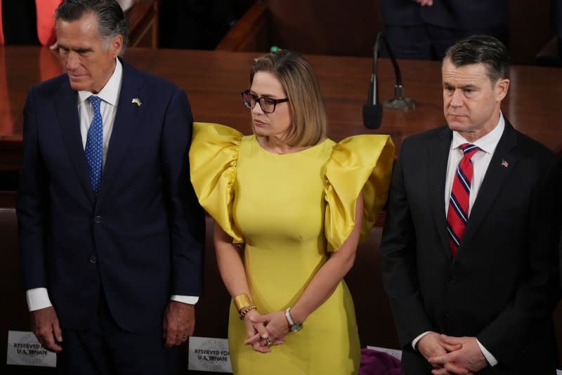 Sen. Kyrsten Sinema, I-Ariz. (C), stands with Sen. Mitt Romney, R-Utah (L), and Sen. Todd Young, R-Ind., in the Senate chamber before President Joe Biden's 2023 State of the Union address in February. File Photo by Pat Benic/UPI