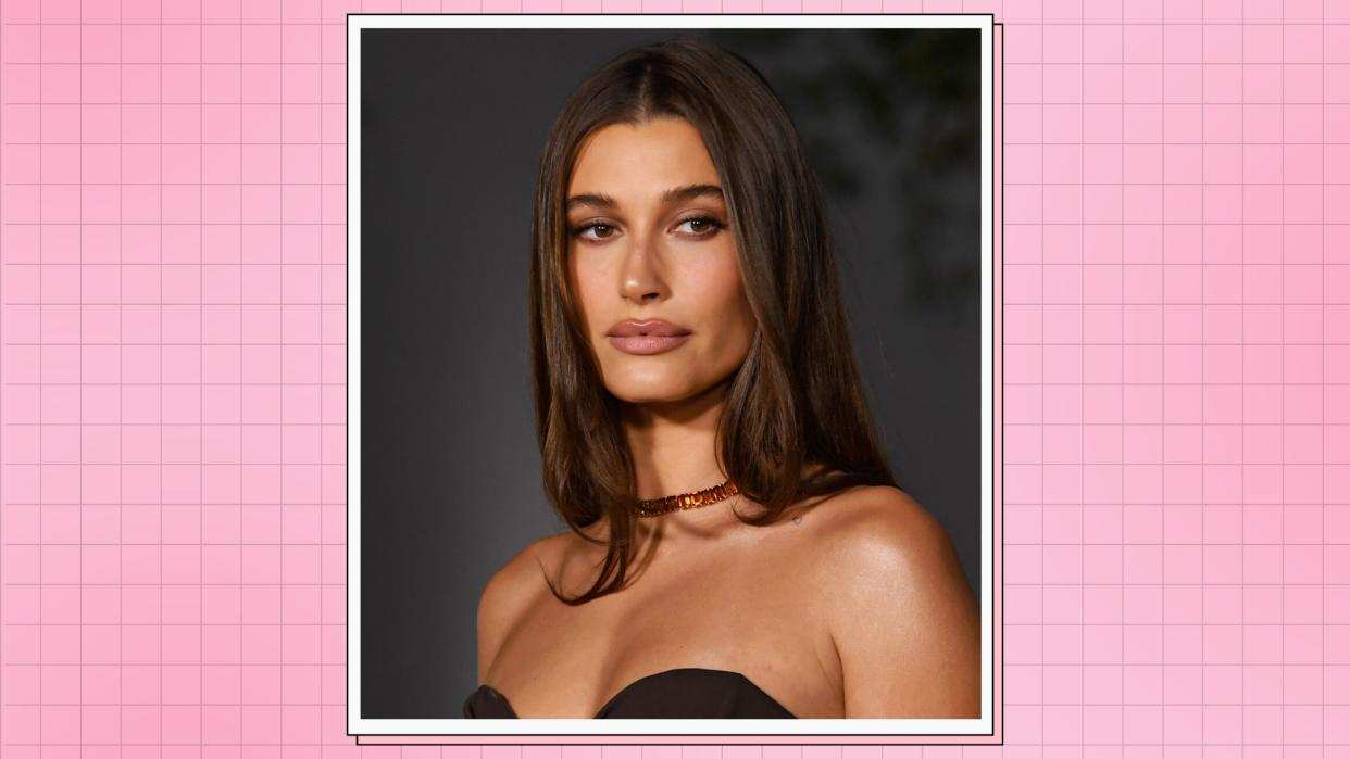  Hailey Bieber pictured with soft, nude makeup and wearing a brown dress at the 2nd Annual Academy Museum Gala at Academy Museum of Motion Pictures on October 15, 2022 in Los Angeles, California. / in a pink template 