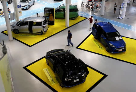 A visitor walks between Toyota Motor Corp's cars displayed at the company's showroom in Tokyo, Japan, August 4, 2015. REUTERS/Yuya Shino