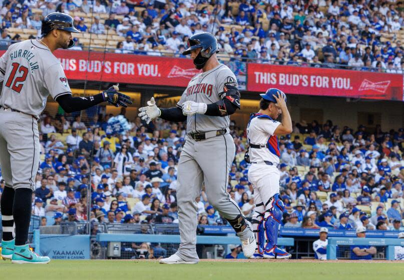 LOS ANGELES, CA - JULY 4, 2024: Arizona Diamondbacks first base Christian Walker (53) is greeted at home plate by Arizona Diamondbacks outfielder Lourdes Gurriel Jr. (12) hitting a homer in the first inning against the Dodgers at Dodgers Stadium on July 4, 2024 inLos Angeles, California. Los Angeles Dodgers catcher Austin Barnes (15) stands on the right. (Gina Ferazzi / Los Angeles Times)