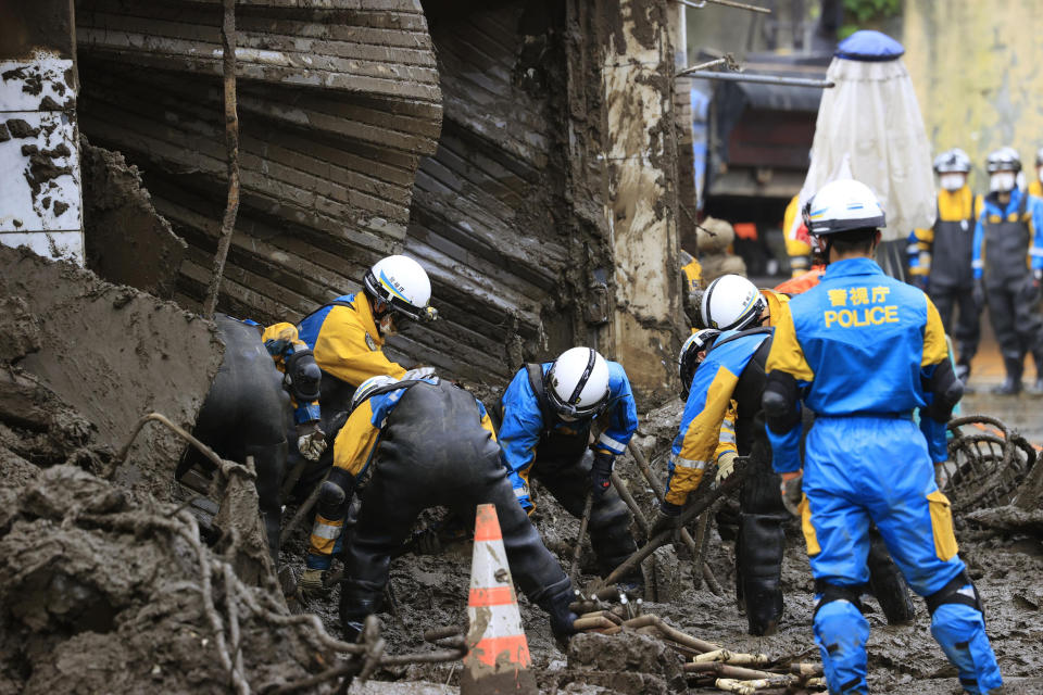 Police officers continue a search operation for missing people at the site of a mudslide in Atami, southwest of Tokyo Tuesday, July 6, 2021. Rescue workers struggled with sticky mud and risks of more mudslides Tuesday as they searched for people may have been trapped after a torrent of mud that ripped through a seaside hot springs resort. (Kyodo News via AP)