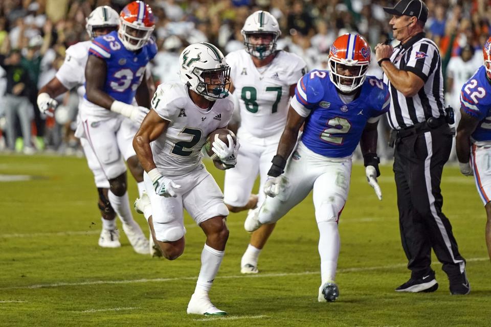 South Florida running back Brian Battie, front left, runs past Florida linebacker Amari Burney (2) for a 10-yard touchdown during the first half of an NCAA college football game, Saturday, Sept. 17, 2022, in Gainesville, Fla. (AP Photo/John Raoux)