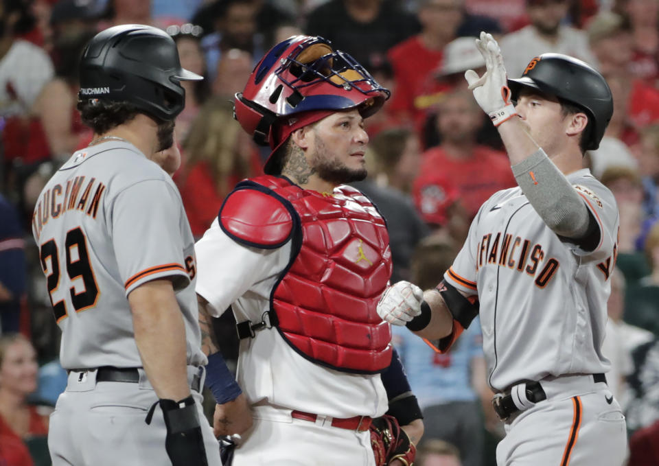 San Francisco Giants' Mike Yastrzemski, right, celebrates with teammate Mike Tauchman after hitting a three-run home run, as St. Louis Cardinals catcher Yadier Molina (4) watches the replay in the seventh inning of a baseball game, Friday, July 16, 2021, in St. Louis. (AP Photo/Tom Gannam)