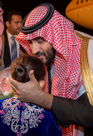 Saudi Arabia's Crown Prince Mohammed bin Salman greets a girl upon his arrival in Algiers, Algeria December 2, 2018. Picture taken December 2, 2018. Bandar Algaloud/Courtesy of Saudi Royal Court/Handout via REUTERS