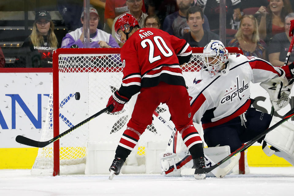 Carolina Hurricanes' Sebastian Aho (20), of Finland, knocks the puck out of the air and past Washington Capitals goaltender Braden Holtby (70) during the third period of an NHL preseason hockey game in Raleigh, N.C., Sunday, Sept. 29, 2019. (AP Photo/Karl B DeBlaker)