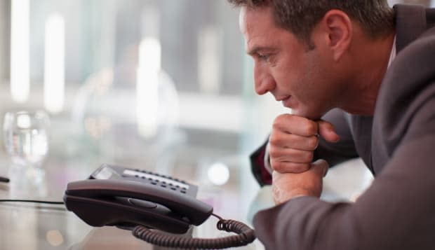 Businessman staring at telephone waiting for it to ring