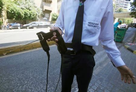 A security personnel, working for a private company, uses a detector as he checks a car entering a mall's parking lot in Beirut, Lebanon July 26, 2016. REUTERS/Jamal Saidi