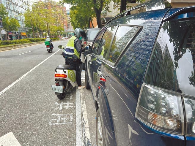 台北市路邊收費車格愈來愈多，停車收費員也成為熱門職缺，不少人為拚業績穿梭大街小巷搶開單，只為賺取高額獎金。（黃婉婷攝）