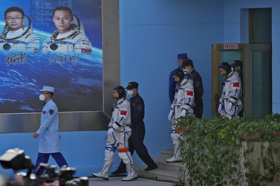 Chinese astronauts for the Shenzhou-18 mission, from left, Li Guangsu, Ye Guangfu and Li Cong walk out from a building during a send-off ceremony for their manned space mission at the Jiuquan Satellite Launch Center in northwestern China, Thursday, April 25, 2024. (AP Photo/Andy Wong)