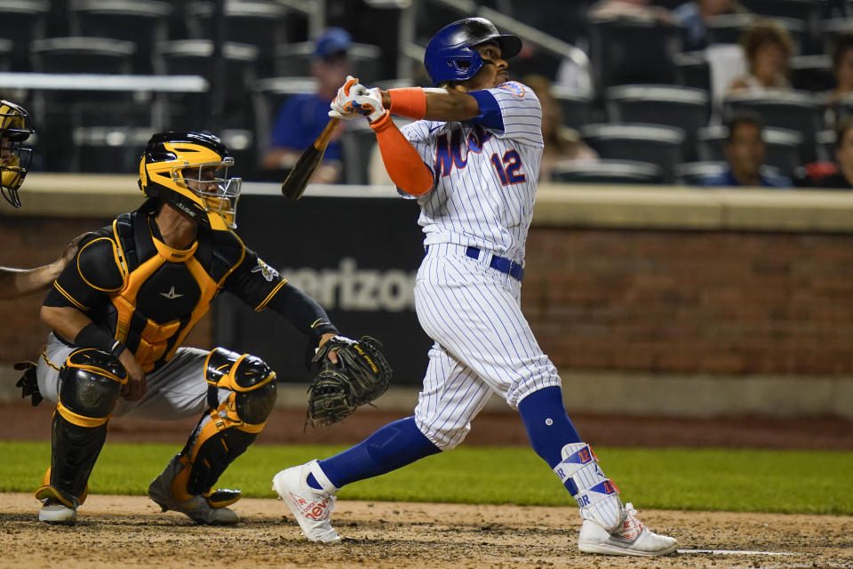 Pittsburgh Pirates catcher Michael Perez watches as New York Mets' Francisco Lindor, right, follows through on a grand slam home run during the sixth inningof a baseball game Friday, July 9, 2021, in New York. (AP Photo/Frank Franklin II)