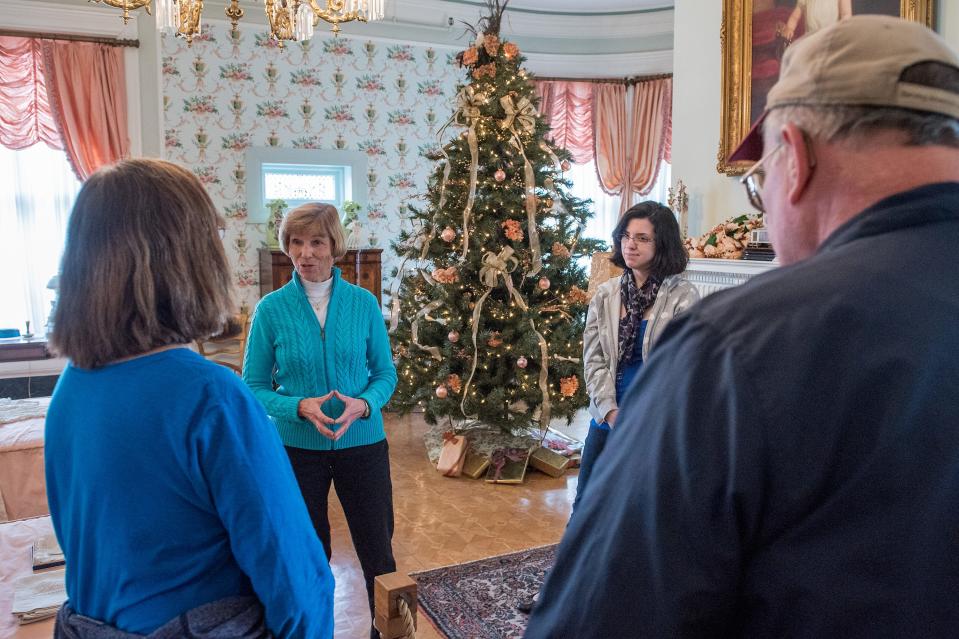 Docents Beth Caldwell, left, and Jil Hickey, answer questions in a bedroom of the Conrad-Caldwell House Museum as they and the Brennan House on Fifth Street downtown join up for a Victorian Holiday Tour. Dec. 13, 2014