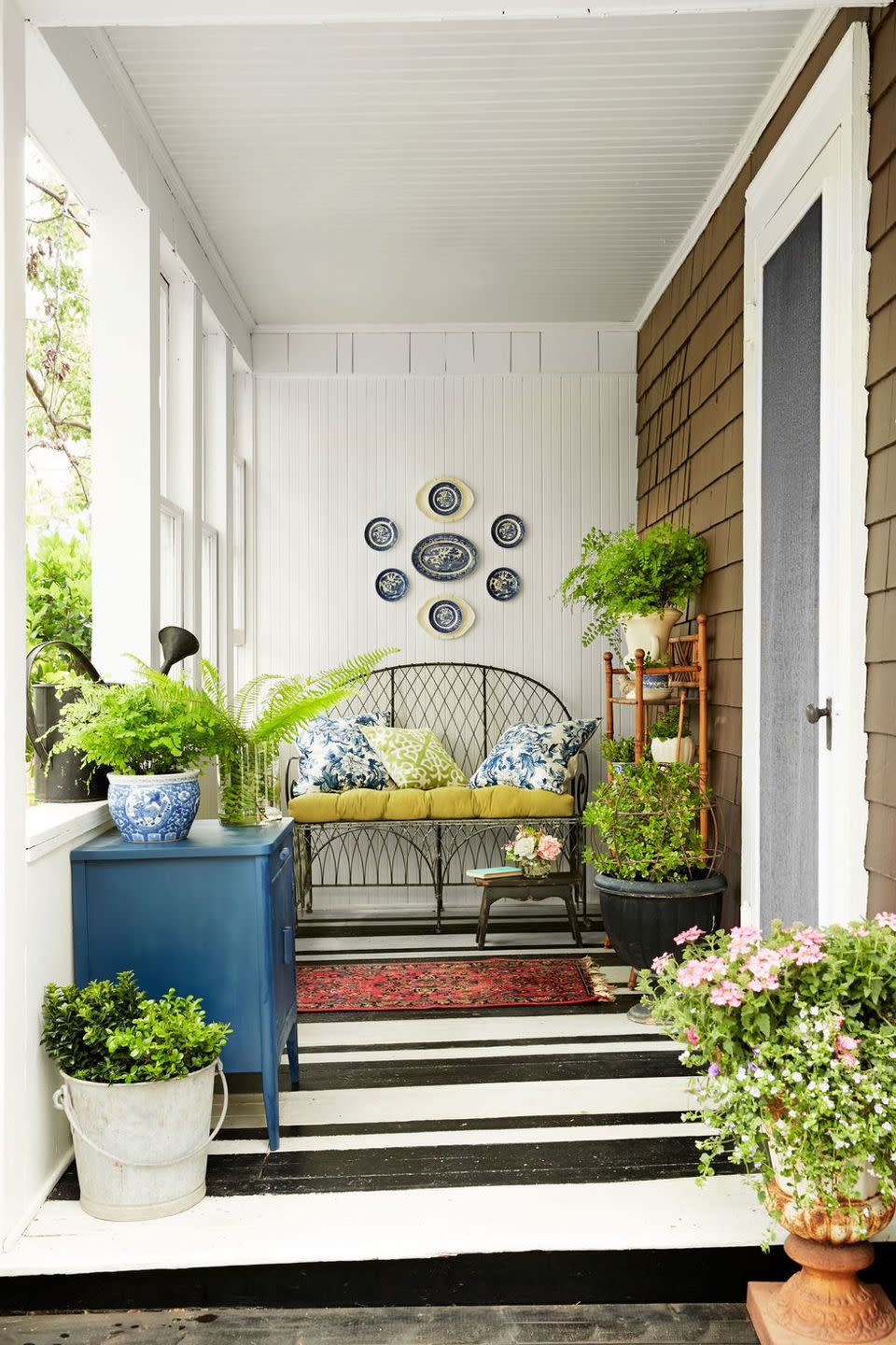 <p>A horizontally striped painted floor make this narrow porch look wider. </p>