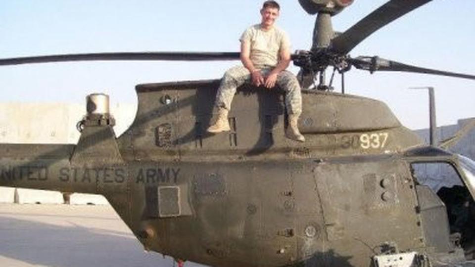 B.B. Sanders sits atop an OH-58D in the desert sun while doing line maintenance during the Iraqi surge. (Photo courtesy of B.B. Sanders)