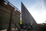 <p>A worker looks between the first section of a newly-constructed structure along the border separating Mexicali, Mexico and Calexico, Calif., March 5, 2018. (Photo: Gregory Bull/AP) </p>