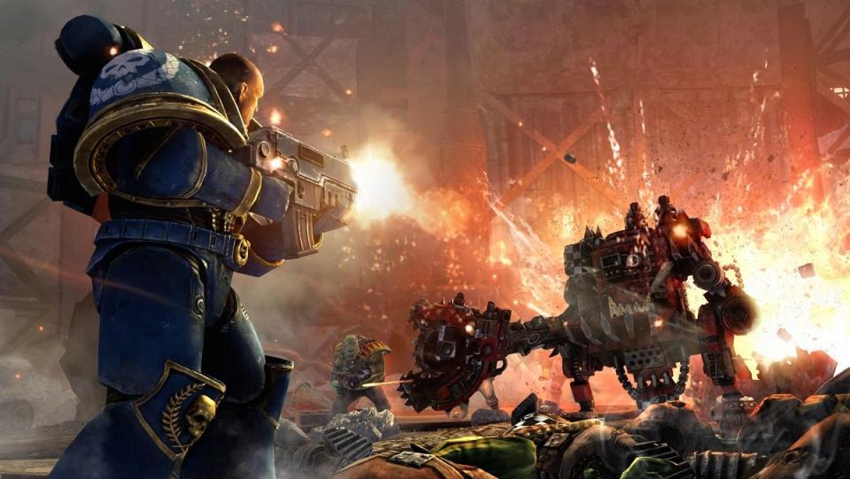 A battle between a Space Marine without a helmet and a big mech looking thing in Warhammer 40k.