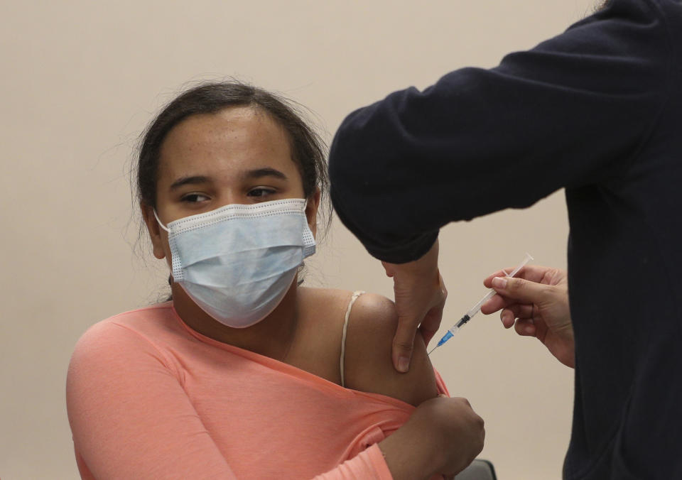 Antonia Torres, 15, is given a first dose of the Pfizer vaccine for COVID-19 at the Teleton Institute, a clinic that specializes in treating chronically ill children in Santiago, Chile, Tuesday, June 22, 2021, on the first day the government started vaccinating youths between ages 12 and 17 who have chronic illnesses. (AP Photo/Esteban Felix)