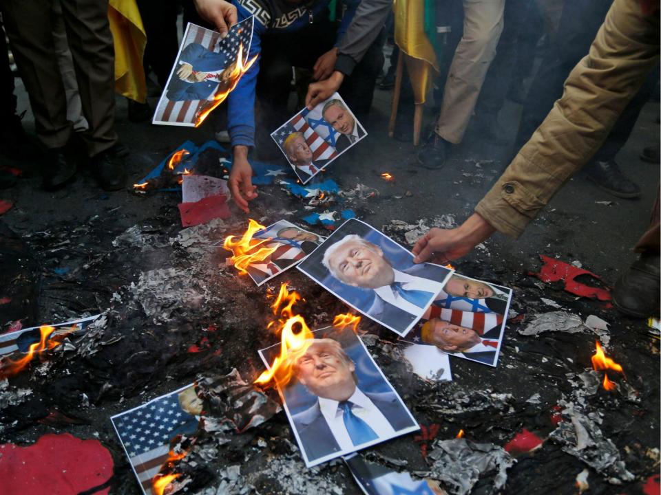 Portraits of the US President were burned during a demonstration in Tehran on 11 December: Getty