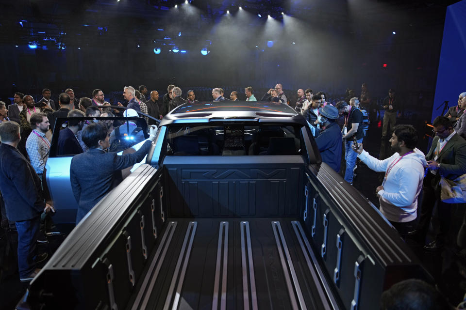 People look inside the Ram 1500 Revolution electric battery powered pickup truck after the Stellantis keynote at the CES tech show Thursday, Jan. 5, 2023, in Las Vegas. (AP Photo/John Locher)