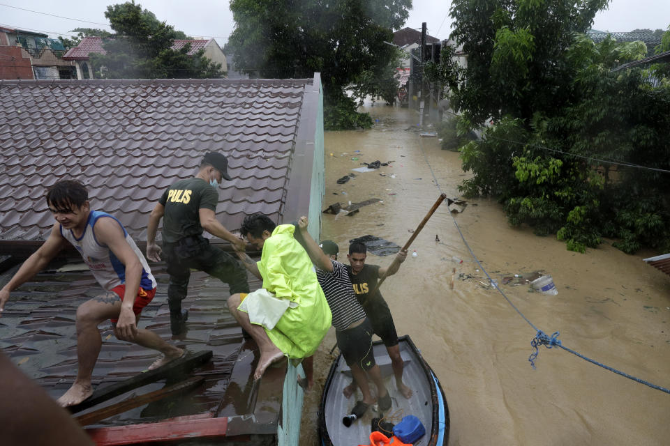 Police rescue residents as floods continue to rise in Marikina, Philippines due to Typhoon Vamco, Thursday, Nov. 12, 2020. A typhoon swelled rivers and flooded low-lying areas as it passed over the storm-battered northeast Philippines, where rescuers were deployed early Thursday to help people flee the rising waters. (AP Photo/Aaron Favila)