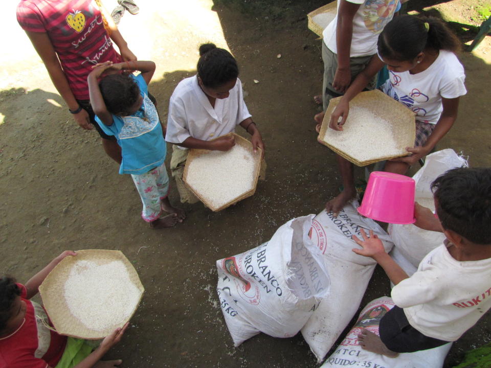 This 2010 photo provided to The Associated Press shows children sifting rice at the Topu Honis children's shelter in Kutet, East Timor. (AP Photo)