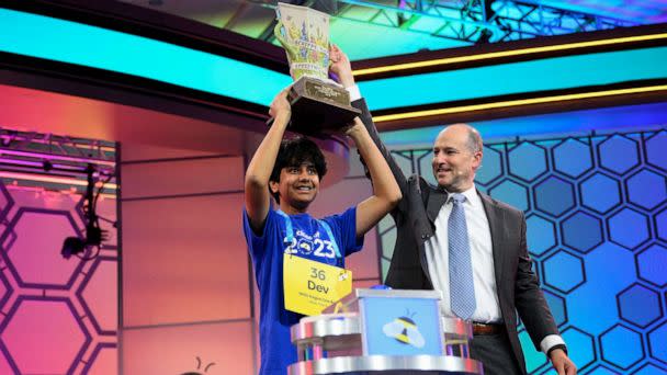 PHOTO: Dev Shah, 14, from Largo, Fla., lifts the trophy next to Scripps CEO Adam Symson after he won the Scripps National Spelling Bee, on June 1, 2023, in Oxon Hill, Md. (Nick Wass/AP)