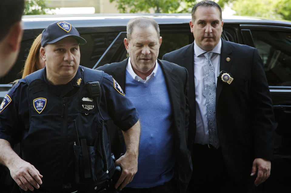 FILE- In this May 25, 2018 file photo, NYPD Detective Nicholas DiGaudio, right, escorts Harvey Weinstein into court in New York. New York prosecutors say the former lead police detective in the sexual assault investigation urged one of Weinstein's accusers to delete information from her phone before turning it over to prosecutors. On Oct. 11, prosecutors had abandoned part of their sexual assault case against Weinstein when evidence surfaced that DiGaudio instructed a witness to keep quiet when she raised doubts about another accuser's claim of sexual misconduct. (AP Photo/Mark Lennihan, File)