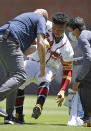 Atlanta Braves' Ronald Acuna Jr. is helped to his feet by trainers after injuring his foot in the seventh inning of a baseball game against the Toronto Blue Jays Thursday, May 13, 2021, in Atlanta. (AP Photo/Ben Margot)