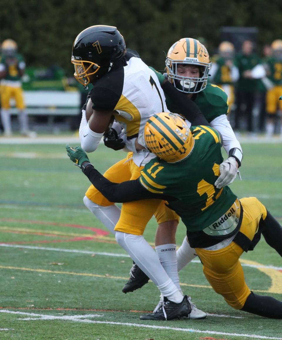 Detroit King receiver Damon Stennis catches a pass against Grosse Pointe North defender Daylon Doe at Grosse Pointe North High School on Friday, Nov. 3, 2023.