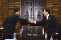 In this photo released by South Korean Unification Ministry, head of South Korean working-level delegation Lee Duk-haeng, right, shakes hands with his North Korean counterpart Park Yong Il during their meeting at Tongilgak in the North Korean side of Panmunjom which has separated the two Koreas since the Korean War, Wednesday, Feb. 5, 2014. Red Cross delegates from the rival Koreas begun talks Wednesday on holding reunions of families separated since the Korean War ended in the early 1950s. (AP Photo/South Korean Unification Ministry)