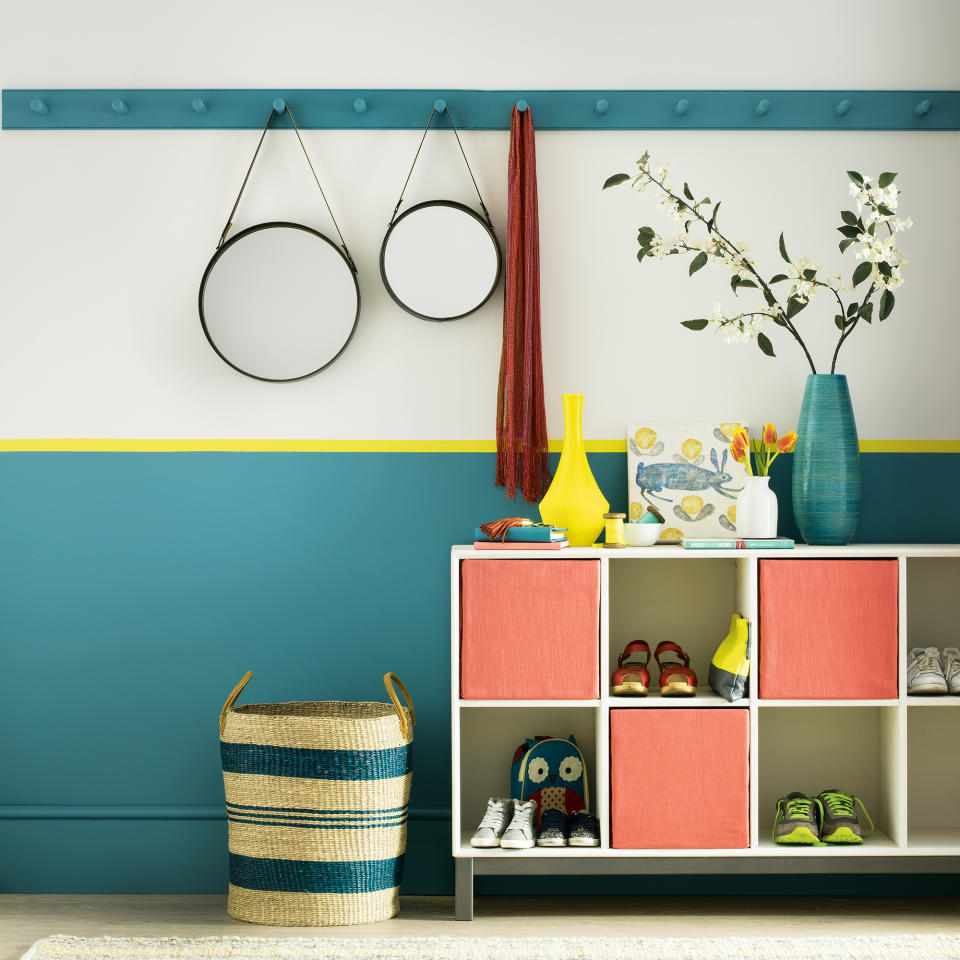 Green and white hallway with shoe storage, mirrors and basket