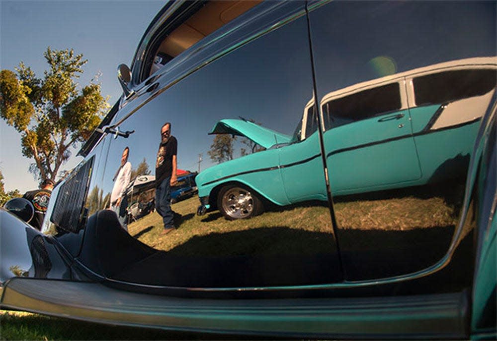 (10/11/20) A 1950s era Chevrolet Bel Air is reflected in the flanks of a 1933 Ford Coupe on display at the 31st annual Pete Paulsen's Hot rod Party cars show in French Camp.