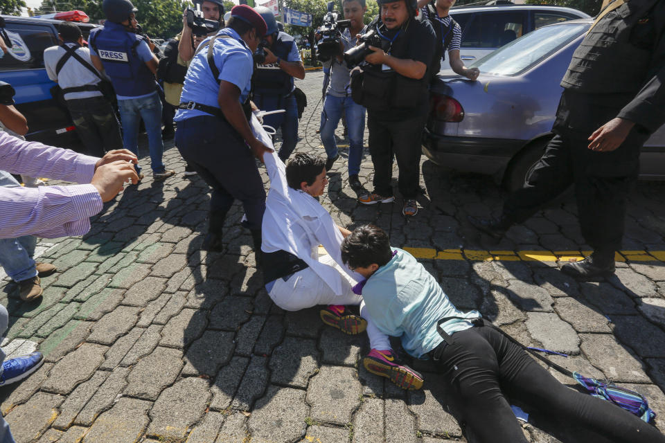 News photographers document anti-government protesters being dragged away and arrested by police as the security forces disrupt an opposition march coined "United for Freedom" in Managua, Nicaragua, Sunday, Oct. 14, 2018. Anti-government protests calling for President Daniel Ortega's resignation are ongoing since April, triggered by a since-rescinded government plan to cut social security pensions. Ortega said opponents will have to wait until his term ends in 2021. (AP Photo/Alfredo Zuniga)