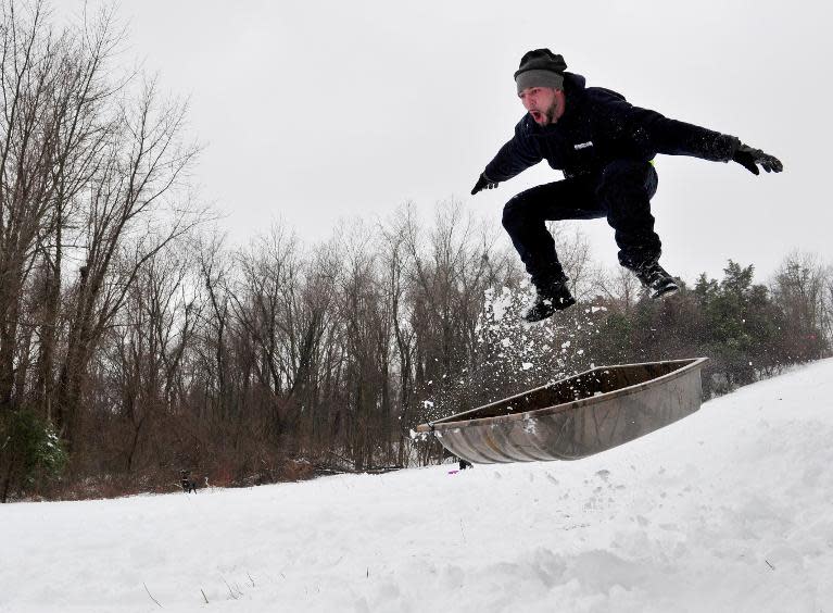 A man goes airborne while sledding on a local hill February 13, 2014 in Manassas, Virginia