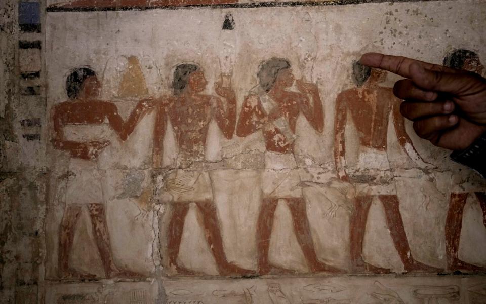 A coloured painting which shows the offer of sacrifices at a recently uncovered tomb - AP/Amr Nabil