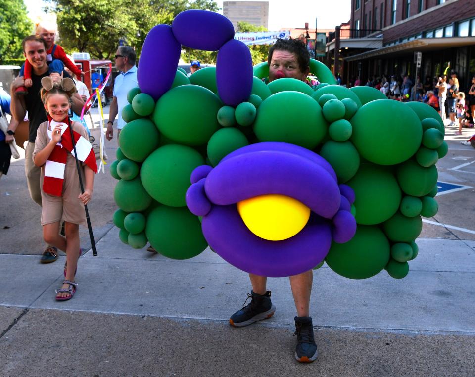 Balloon artist Kornpop wandered Cypress Street wearing a giant “camera” during Thursday’s Children’s Art and Literacy Festival's Storybook Parade.