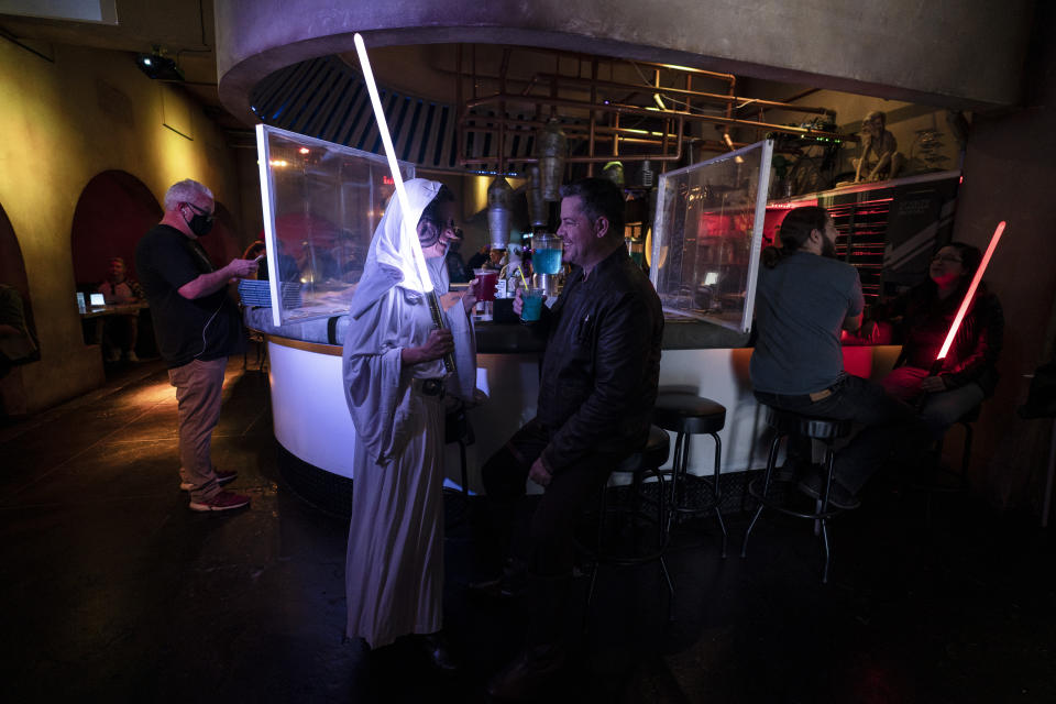 Elen Monocroussos, left, and boyfriend, James Stevens, are dressed in Star Wars costumes as they celebrate Star Wars Day at Scum and Villainy Cantina, a geek bar located on Hollywood Blvd, in Los Angeles, Tuesday, May 4, 2021. California has the lowest infection rate in the country. Los Angeles County, which is home to a quarter of the state's nearly 40 million people and has endured a disproportionate number of the state's 60,000 deaths, didn't record a single COVID-19 death Sunday or Monday, which was likely due to incomplete weekend reporting but still noteworthy. (AP Photo/Jae C. Hong)