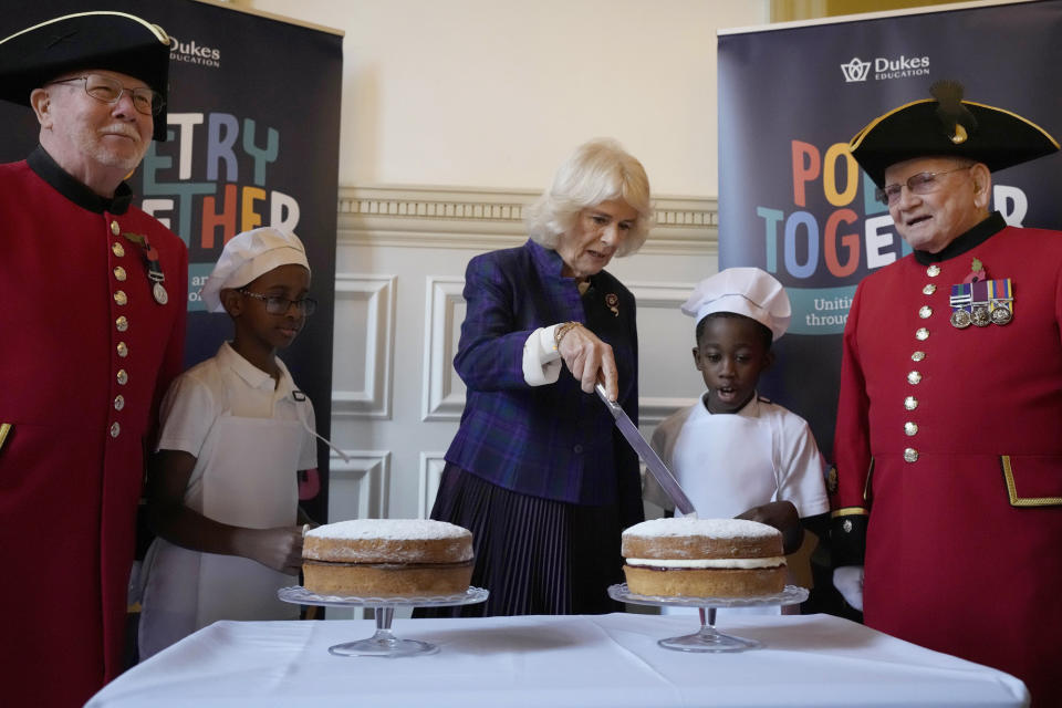 FILE - Britain's Camilla, the Duchess of Cornwall, cuts a victoria sponge cake as she joins children and care home residents for a 'Poetry Together' recital and tea party at the Royal Geographical Society in London, Wednesday, Nov. 10, 2021. (AP Photo/Frank Augstein, Pool, File)